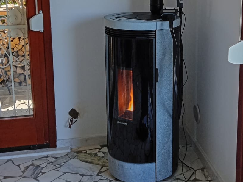 Stufa a pellet con rivestimento in pietra, accesa